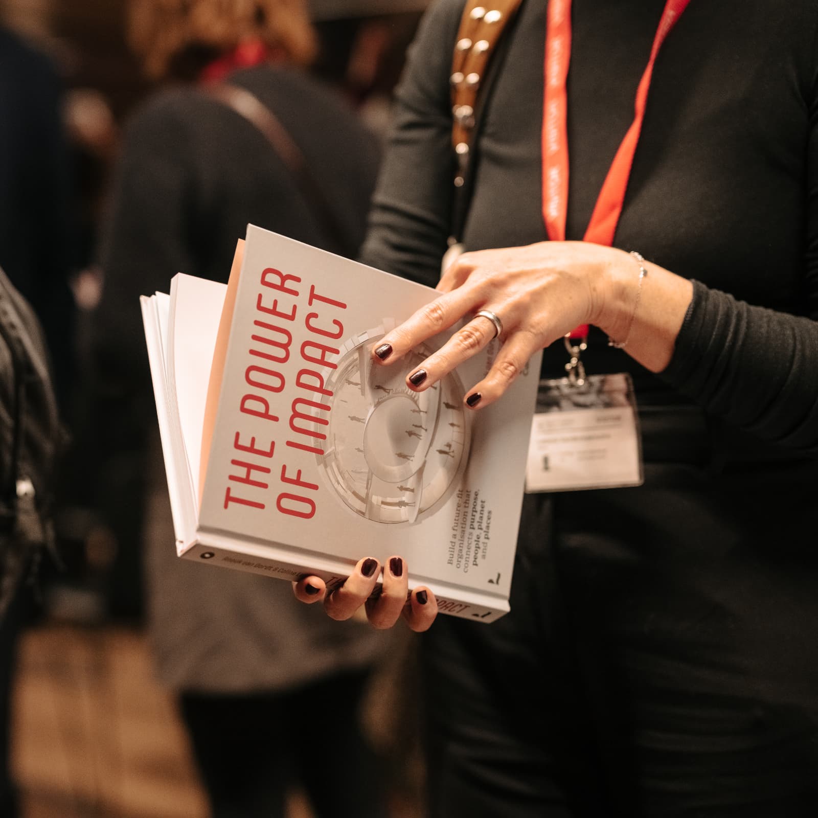 A person is leafing through the book The Power of Impact