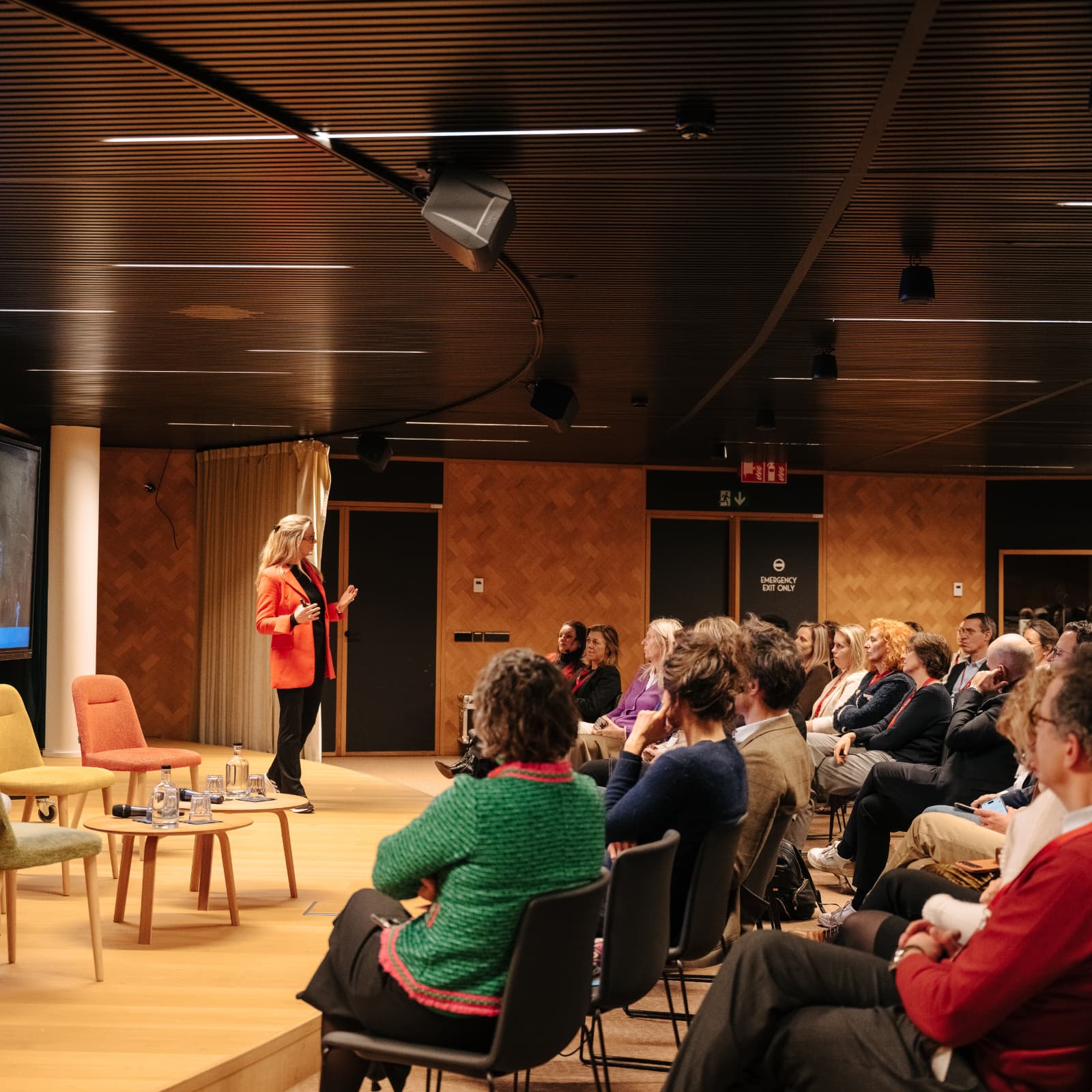 Anouk speaks in front of an audience during a keynote